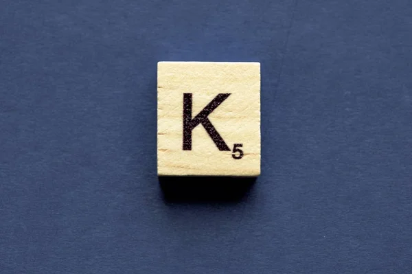 Carta K em um cubo de madeira de um jogo de tabuleiro wordplay — Fotografia de Stock