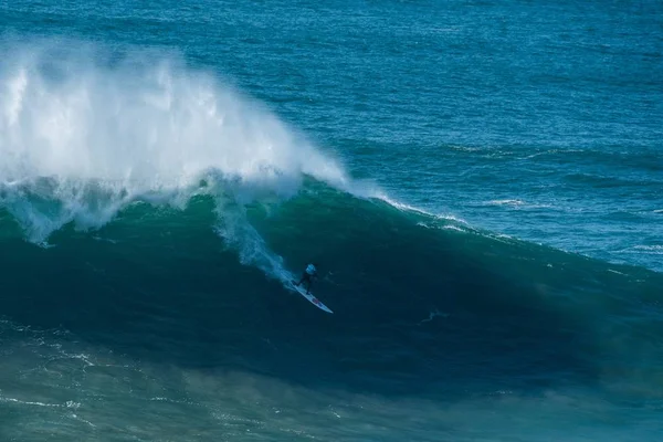 Onda espumosa alta do Oceano Atlântico que leva o surfista para a costa de Nazare, Portugal — Fotografia de Stock