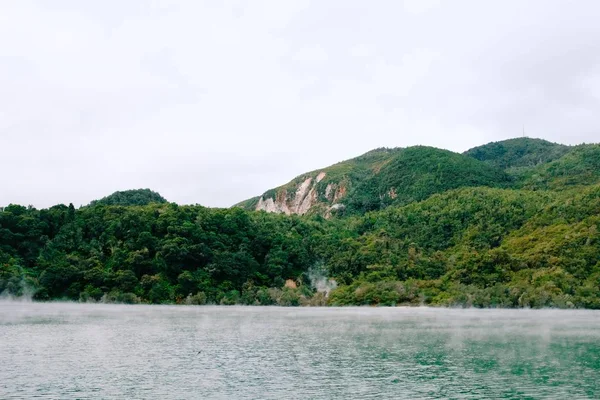 从被青山环绕的美丽水体中喷出的蒸汽 — 图库照片