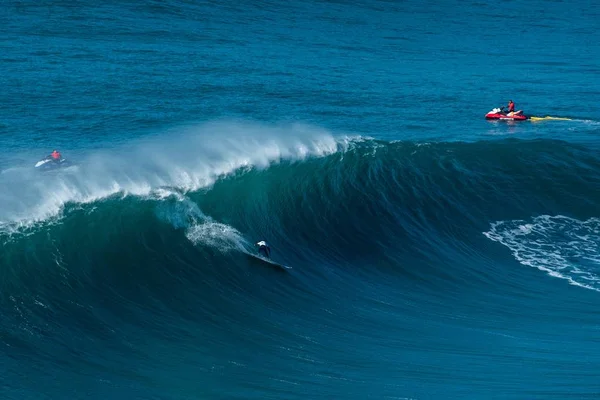 Surfistas nas ondas do Oceano Atlântico em direcção à costa em Nazare, Portugal — Fotografia de Stock