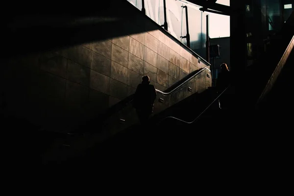 一个黑暗的地下区域 两个人走下楼梯 — 图库照片