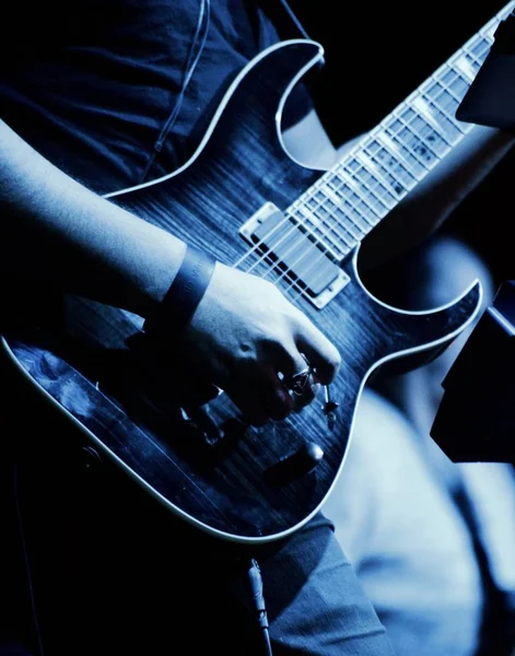 Vertikální Záběr Hudebníka Držícího Elektrickou Kytaru Pod Modrým Světlem Vystupujícího — Stock fotografie