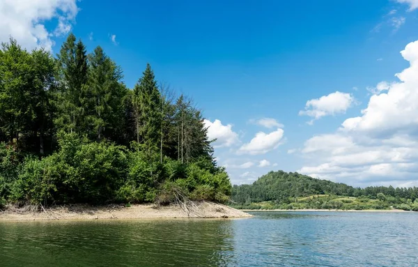 湖中美丽的风景，周围环绕着高大的绿树，反映在水面上 — 图库照片