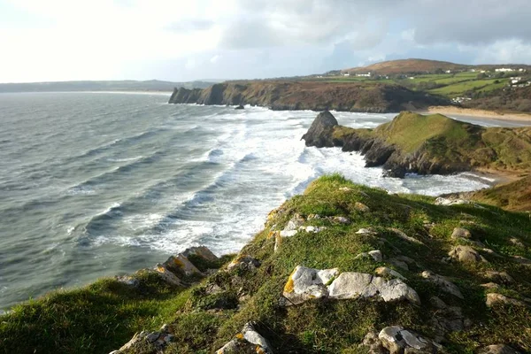Hermoso paisaje de olas oceánicas moviéndose hacia la orilla salpicando a la formación de rocas —  Fotos de Stock