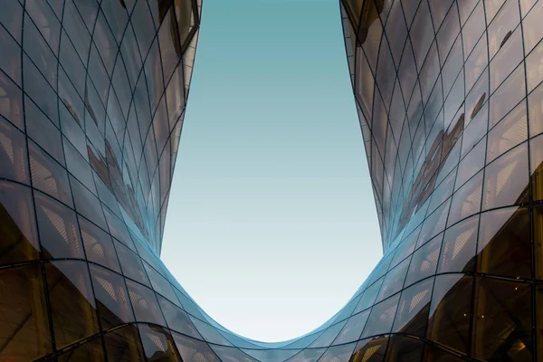 Estrutura em forma de U de vidro com o céu azul no fundo — Fotografia de Stock