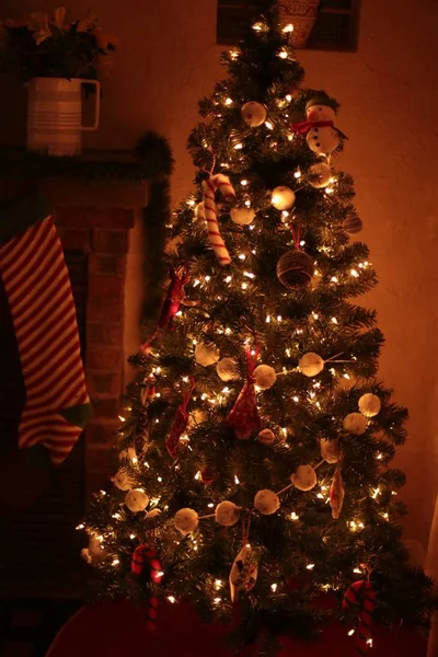 Uma árvore de Natal lindamente decorada em ambientes fechados com luzes brilhantes e em uma casa acolhedora — Fotografia de Stock