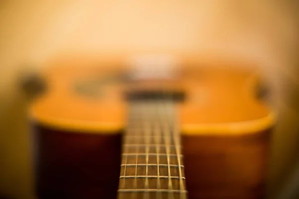 Niewyraźne ujęcie gitary akustycznej z rozmytym tłem — Zdjęcie stockowe