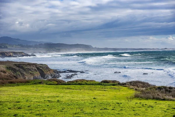 海岸の緑の岩の形成に灯台の美しいショット — ストック写真