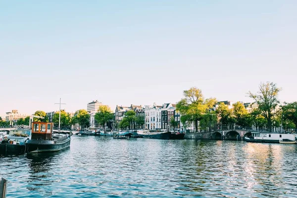 Prachtig uitzicht op de boten en de gebouwen aan de rivier onder de blauwe lucht — Stockfoto