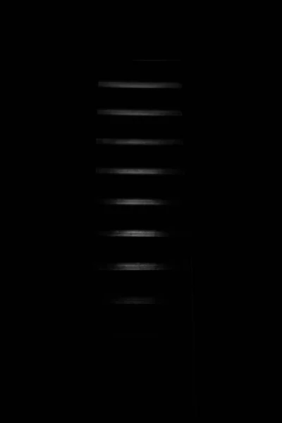 Pionowe ujęcie wieży kija w czarnym pomieszczeniu idealne na neutralne tło — Zdjęcie stockowe