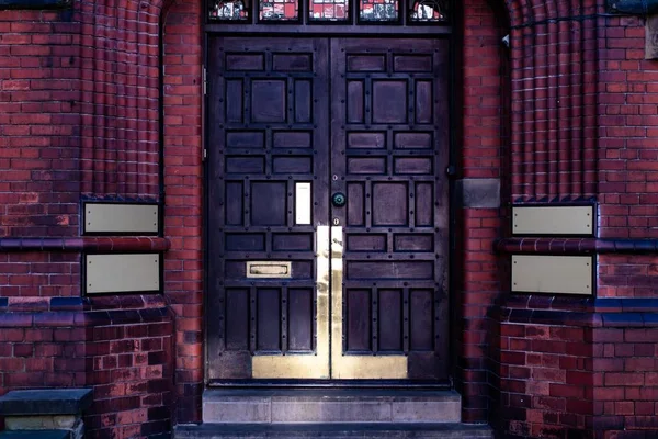 Gebouw ingang met een vintage deur in het midden van een rode boog — Stockfoto