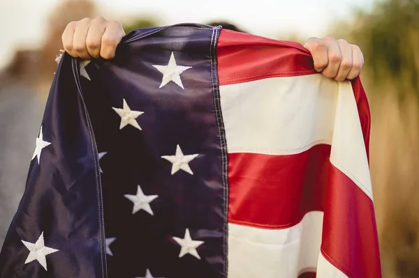 Primer plano de las manos humanas sosteniendo la bandera de los Estados Unidos —  Fotos de Stock