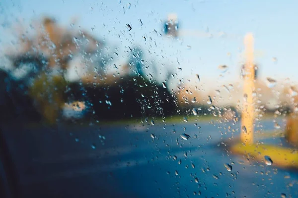 Ujęcie z bliska mokrego szkła patrzącego na ulicę podczas deszczu — Zdjęcie stockowe