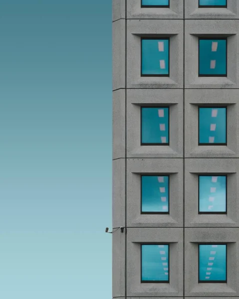 Plan vertical d'un bâtiment en béton gris avec le ciel bleu en arrière-plan — Photo