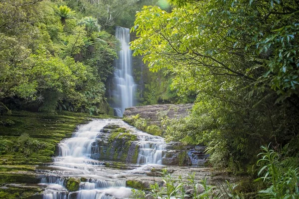 Landschaft eines schönen Wasserfalls in einem Wald, umgeben von viel Grün unter Sonnenlicht — Stockfoto