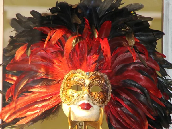 Golden carnival mask for festivals and performances with blue and red feathers around it — ストック写真
