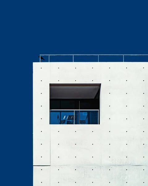 Vertical tiro de ângulo baixo de um edifício branco sob o céu azul claro — Fotografia de Stock