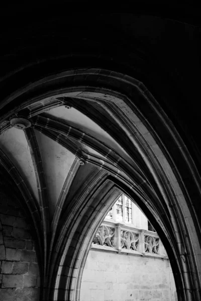 Vertical grey scale shot of the arch shaped entrance of an old building — Stock Photo, Image