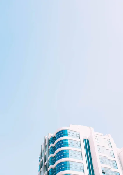 Scatto verticale ad angolo basso di un edificio di vetro sotto il cielo blu catturato a Singapore — Foto Stock