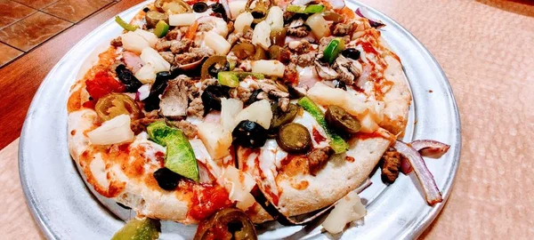 Heerlijke pizza met vers vlees, champignons, augurken en olijven — Stockfoto