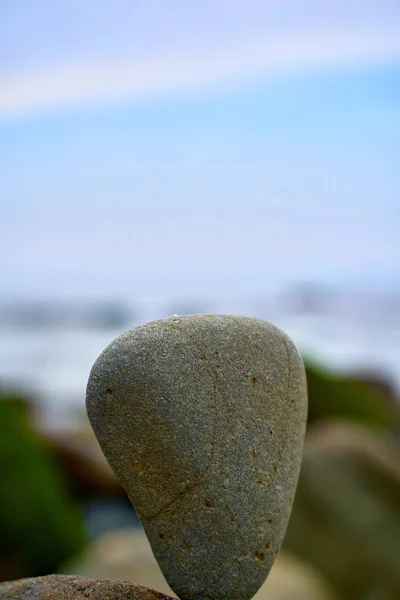 Primer plano vertical de una piedra con un fondo borroso — Foto de Stock