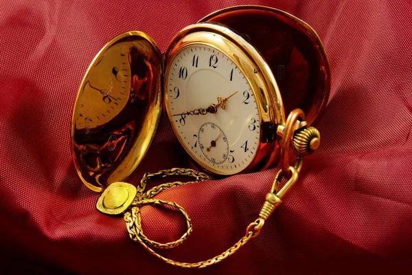 Gros plan d'une vieille montre de poche vintage sur une surface rouge — Photo
