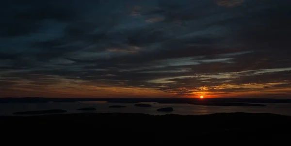 Amplo tiro do pôr do sol de tirar o fôlego no céu nublado sobre o oceano — Fotografia de Stock
