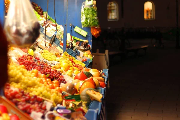 Mercado callejero de frutas y verduras con un parque en un fondo borroso durante la noche —  Fotos de Stock