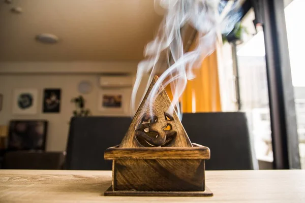 방 안에 있는 테이블 위의 나무 자국에서 현자 연기가 나오고 있습니다. — 스톡 사진
