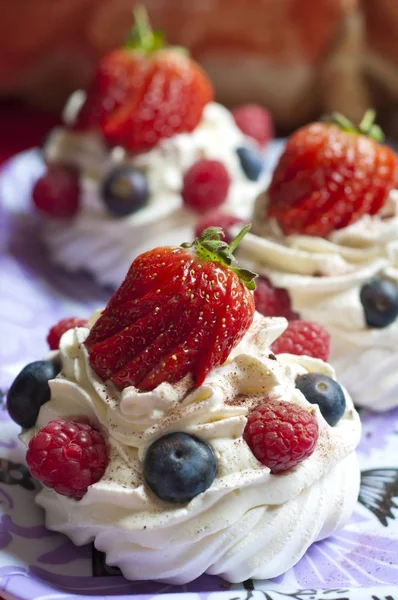 Gros plan vertical de cupcakes crémeux avec garniture fraise, framboise et myrtille — Photo