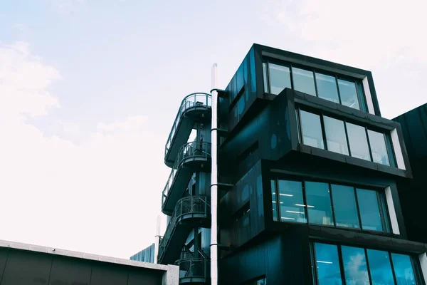 Low angle shot van een moderne architectonische structuur met een glazen gevel — Stockfoto