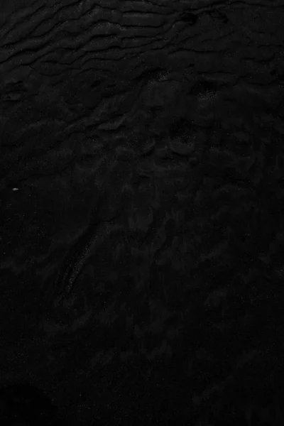 Κάθετη κοντινή λήψη μαύρης υγρής άμμου ιδανική για χρήση ως ουδέτερο φόντο — Φωτογραφία Αρχείου