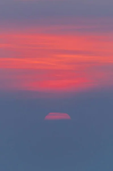 Tiro vertical de tirar o fôlego do belo pôr do sol com cores quentes vibrantes trazendo beleza — Fotografia de Stock