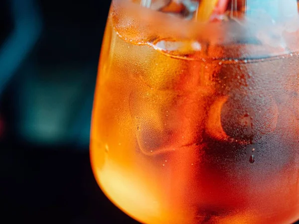 Close-up van een glas met ijs en cocktail erin tegen een wazige achtergrond — Stockfoto