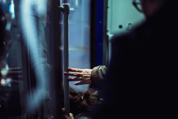 Человек, держащийся на столбе в метро — стоковое фото