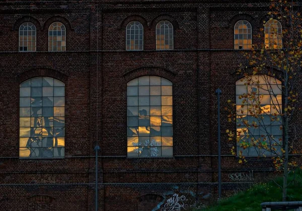 Hermosa foto de un edificio de ladrillo con grandes ventanas y graffiti en las paredes — Foto de Stock