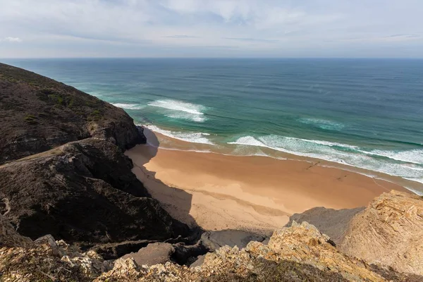 Vista para uma praia rodeada de mar e rochas sob um céu azul em Portugal, Algarve — Fotografia de Stock