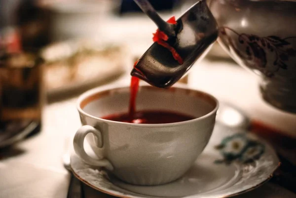 Närbild skott av en kopp röd soppa och andra köksredskap på ett bord — Stockfoto
