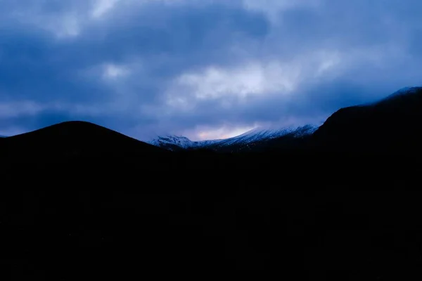 Hermosa silueta de altas montañas rocosas bajo el oscuro cielo nocturno — Foto de Stock