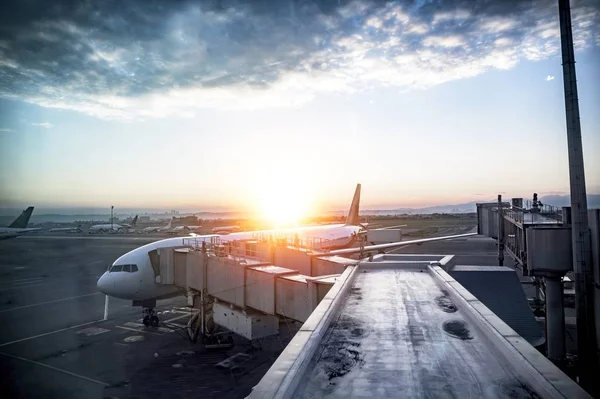 Schöne Aufnahme eines Flugzeugs am Bahnhof mit der Sonne im Hintergrund — Stockfoto