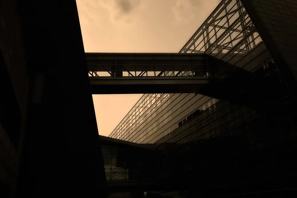 Vue à angle bas d'un bâtiment moderne avec des murs de verre sous un ciel nuageux au coucher du soleil — Photo