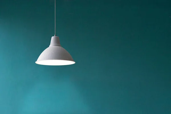 Педантная белая лампа висит перед синей стеной — стоковое фото
