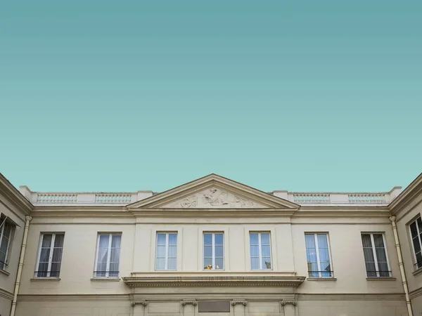 Low angle shot of an old white cement building under the blue sky — Stock Photo, Image