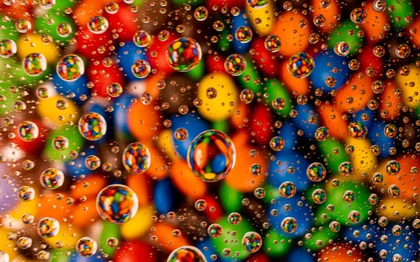 Cool bakgrund av färgglada söta godis under glaset täckt med vattendroppar — Stockfoto