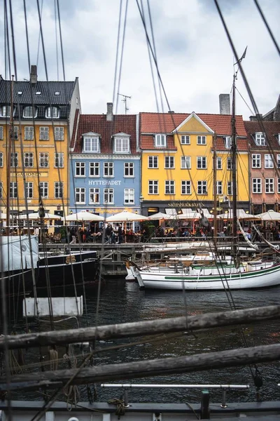 Tiro vertical dos edifícios coloridos e barco pelo porto de Nyhavn capturado em Copenhague, Dinamarca — Fotografia de Stock