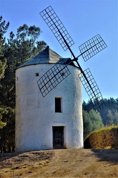 Nahaufnahme einer weißen Windmühle auf einem grünen Hügel unter klarem Himmel — Stockfoto