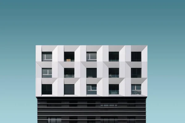 Disparo de ángulo bajo de un edificio moderno de metal plateado y negro bajo el cielo azul —  Fotos de Stock