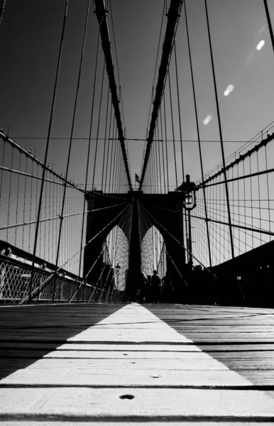 Balança de cinza vertical de uma ponte tocando o céu claro — Fotografia de Stock