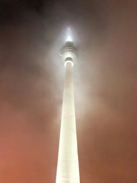 Uma Torre Com Luzes Brancas Cobertas Nevoeiro Sob Céu Noturno — Fotografia de Stock