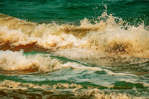 Close-up shot van de turquoise oceaan golven spatten schuimig water — Stockfoto